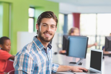 Teacher using laptop in classroom