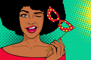 Pop art face. Young sexy african woman with carnival mask in her hand smiling and winking on dots background. Vector illustration in retro comic style. Holiday party invitation poster.
