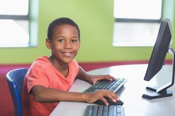 Schoolboy using computer in classroom