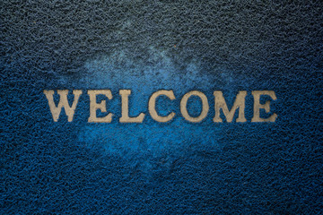 Gold Welcome character on old blue mat with warm light, matted background & textured : Your text design & copy space

