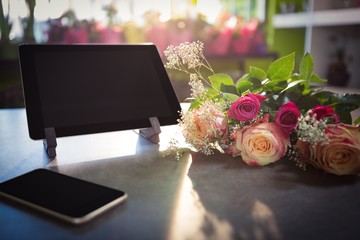 Obraz premium Flower bouquet with smartphone and digital tablet on the table