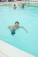 Young boy kid child splashing in swimming pool having fun leisur