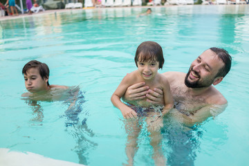 Young boy kid child splashing in swimming pool having fun leisur