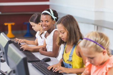 Schoolgirls using computer in classroom