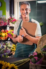 Male florist holding clipboard