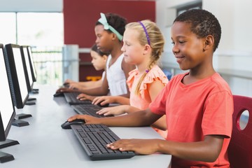 School kids using computer in classroom
