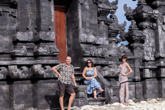 Two caucasian women in sunglasses and one man near the balinese temple. Explore Indonesia, Bali.