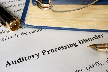 Auditory processing disorder APD on a sheet on an office table.
