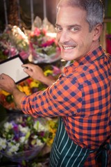 Male florist taking photo of flower bouquet