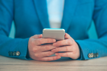 Businesswoman using smartphone, close up of hands
