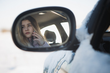 teen girl drive in the car, on the road talking on the phone