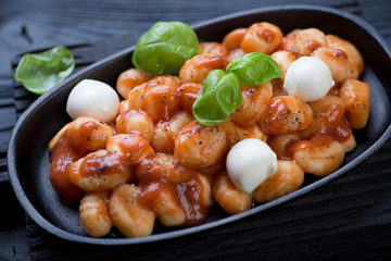 Close-up of potato gnocchi with tomato sauce and mozzarella balls
