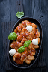 Potato gnocchi served with tomato sauce, cheese and basil leaves