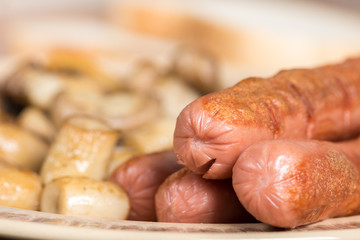 Fried sausages with sliced fried mushrooms