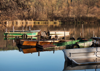 Old fishing boats on the quiet lake in autumn