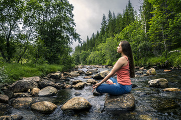 Young woman sitting on the stone, Norway