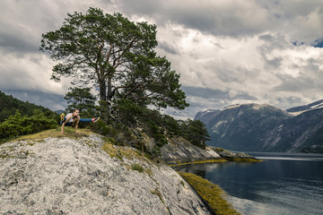 Fototapeta premium Young and sporty woman posing on the rocks, Norway