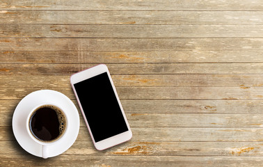 Fototapeta na wymiar Smart phone with blank screen area and coffee cup
