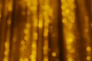 Gold curtain with garland in a blur. Abstract background without focus