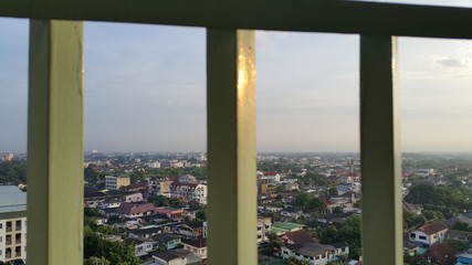 Fototapeta na wymiar City view through the balcony cage.