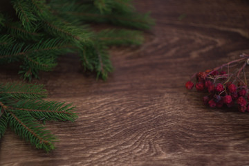 Christmas-tree branch and berries on a wooden background