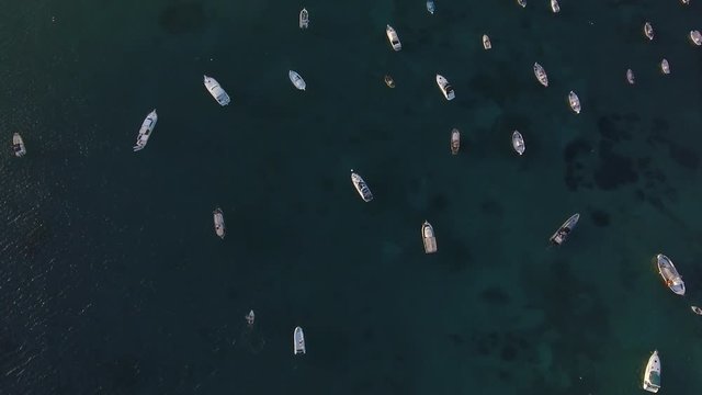 Aerial top down of boats and dinghies lying like toys in the harbour.