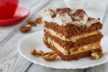 Tiramisu cake with walnuts and coffee on a wooden background