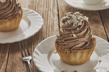 Air cake in a basket with chocolate cream and coffee on a wooden background