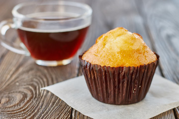 Muffins and a cup of tea on a wooden background