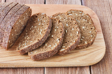 Slice of rye bread with seeds on a wooden background сlose up.