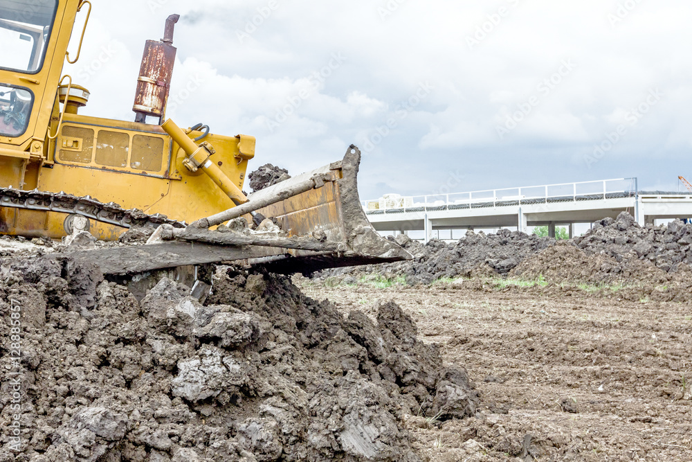 Wall mural heavy earthmover construction machine is moving earth at buildin