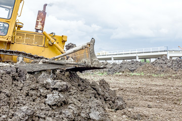 Fototapeta premium Heavy earthmover construction machine is moving earth at buildin