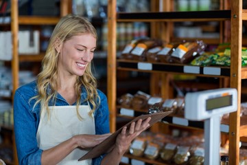 Smiling female staff looking at clipboard