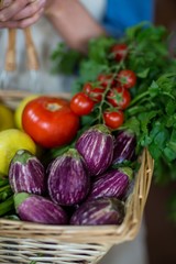 Close-up of staff holding basket of vegetables 