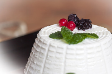 Ricotta cheese with berries and some leaves of green fresh mint
