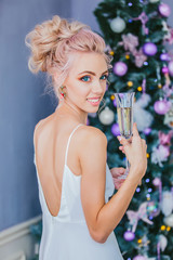 portrait of a luxurious blonde in a white dress at the Christmas