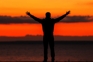 silhouette of a man on the beach, on a background of sea sunset