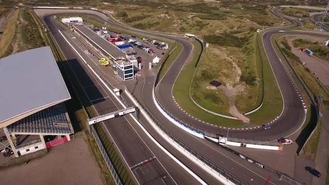 Aerial of a single car racing on race circuit Zandvoort on a sunny day.