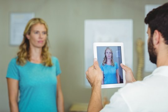 Physiotherapist taking a photograph of a patient 