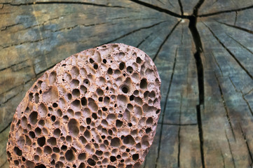 pumice stone with a cord on old wooden background