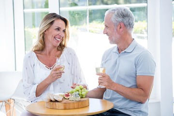 Mature couple holding champagne at restaurant