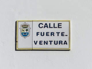 Street sign reading Fuerteventura road on a house front at the C