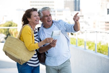 Joyful couple holding map