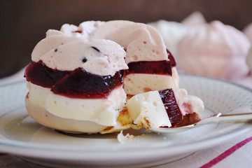 Layered dessert - delicate souffle and fruit marmalade on pastry bathed in white chocolate. Festive cake with currant flavor, in the form of rings.