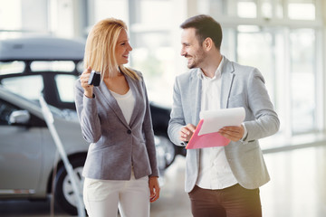 Fototapeta premium Salesperson selling cars at dealership