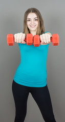Fototapeta na wymiar girl with dumpbells on grey background sport concept gym