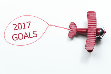 writing 2017 Goals red toy airplane with talk bubble on white background