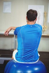 Man sitting on exercise ball