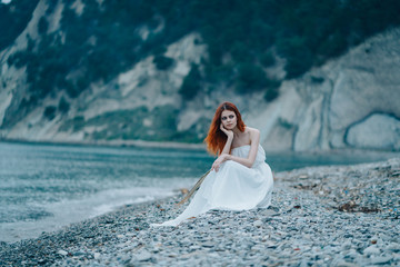 Fototapeta na wymiar Woman on the beach in a white dress
