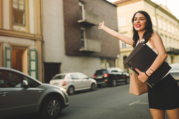 Happy businesswoman hailing taxi